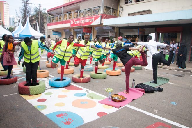 narissa child of the earth teaching yoga at street festival nairobi kenya warrior pose